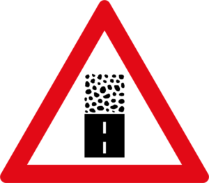 Unpaved road surface ahead sign